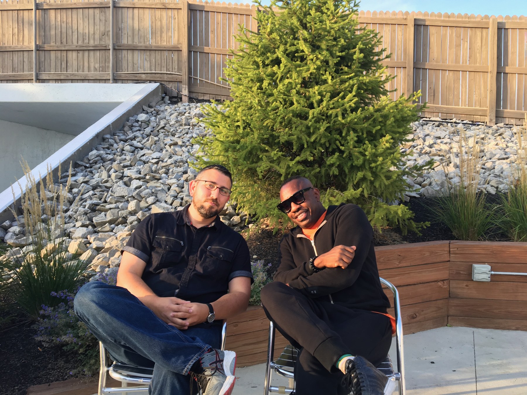 Miguel with Steve Jordan, seated outdoors.